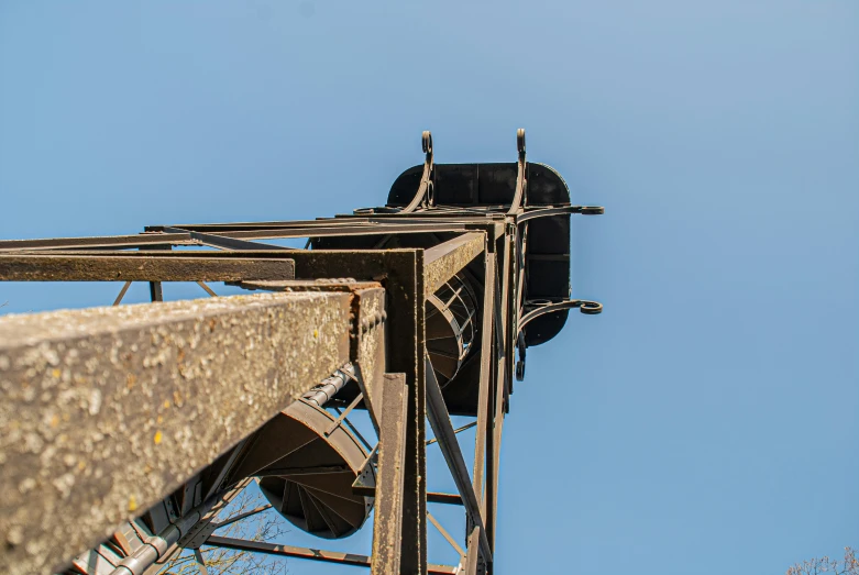 an old looking industrial water pump in front of a blue sky