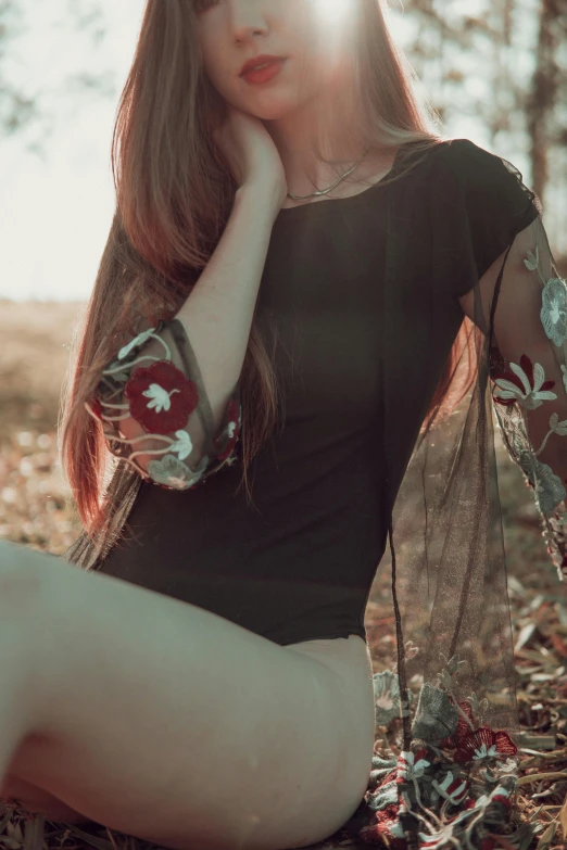 a beautiful young lady sitting in a field