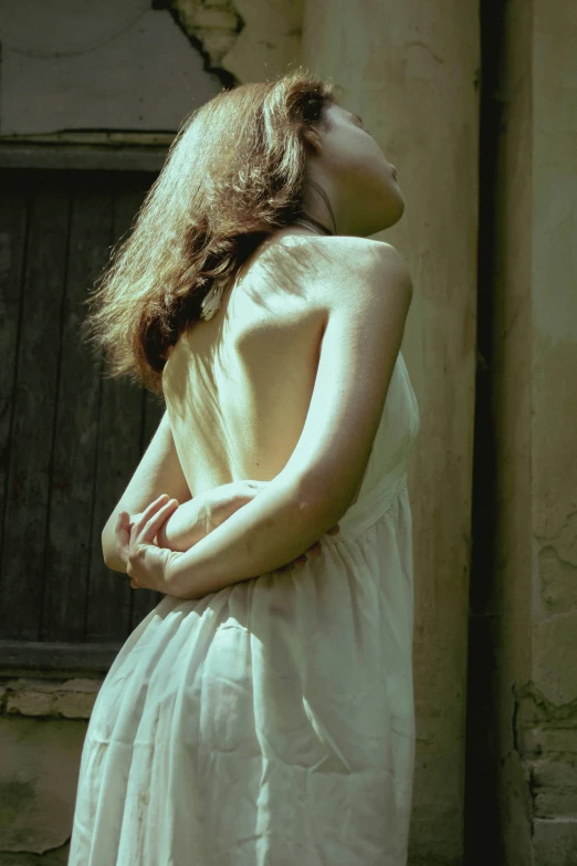 a woman with long hair is standing in front of a window