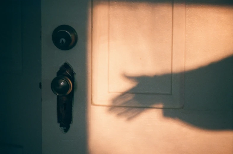 a shadow of someone's hand on the door 