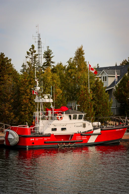a boat with canadian flags docked in a lake