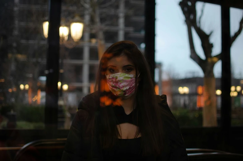 a woman wearing a face mask looking into the window