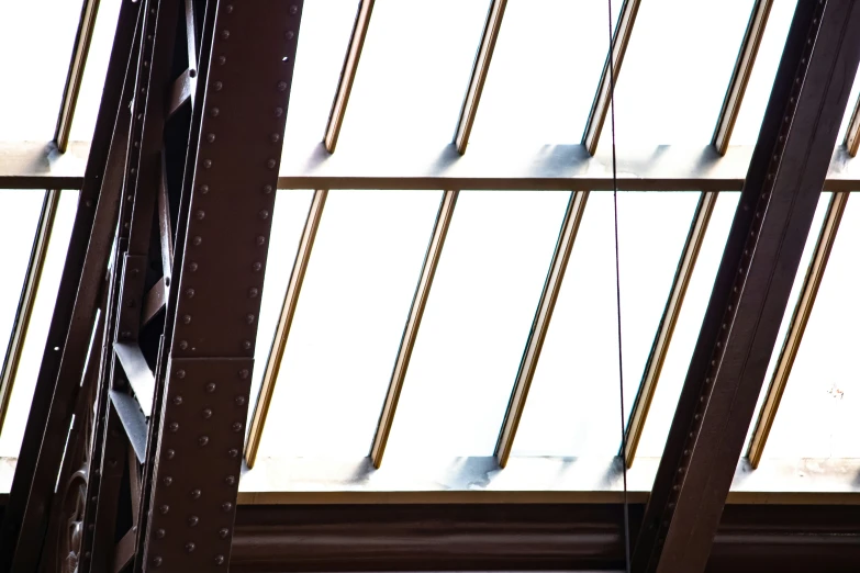 two tall metal beams in the ceiling near windows