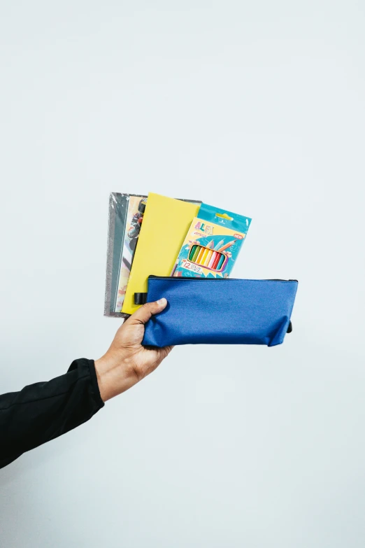 a person holding a blue case with books in it