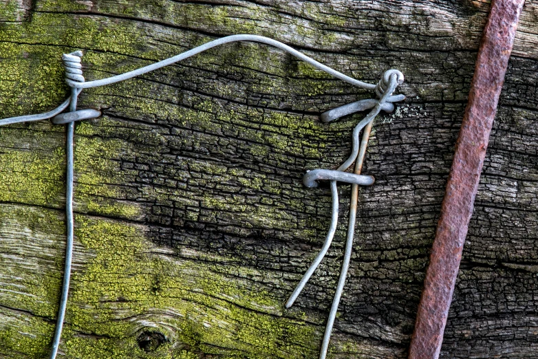 the fence is connected to two wires that are mounted on the wood