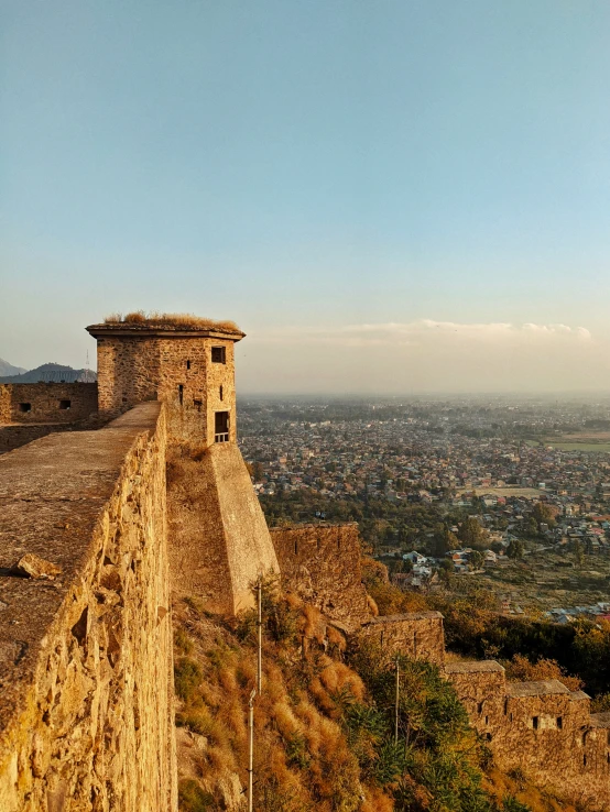 a scenic scene of a castle with mountains and a city in the distance