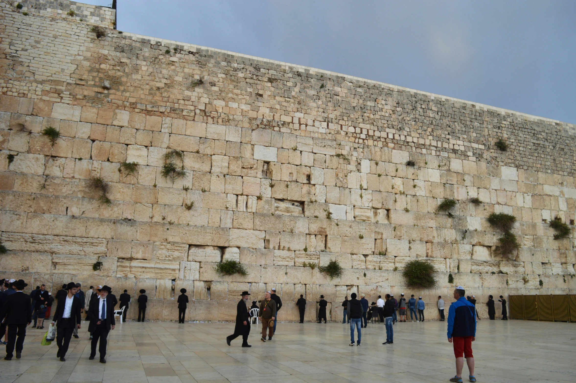 several people at the western wall in the city