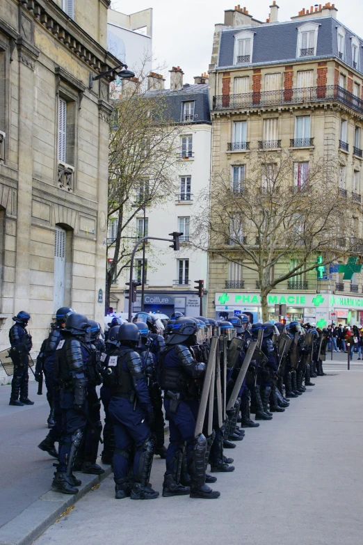 several police officers stand at the curb in front of a large building