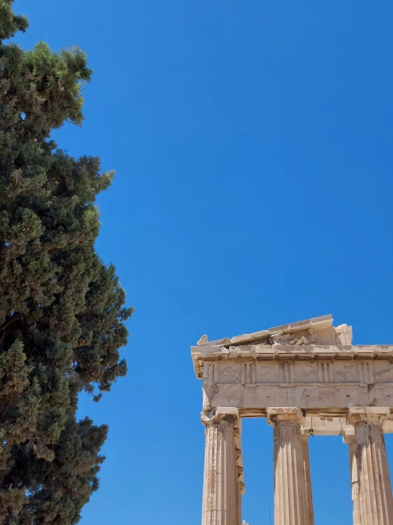 a stone pillar in the foreground and trees on the other side