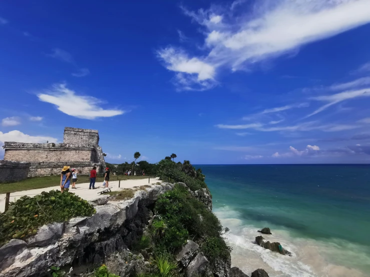 the ocean next to a stone wall near an island