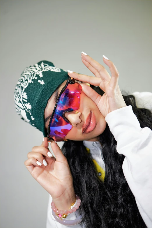 a woman holding a green hat on top of her head