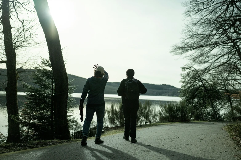 two people are standing together and waving