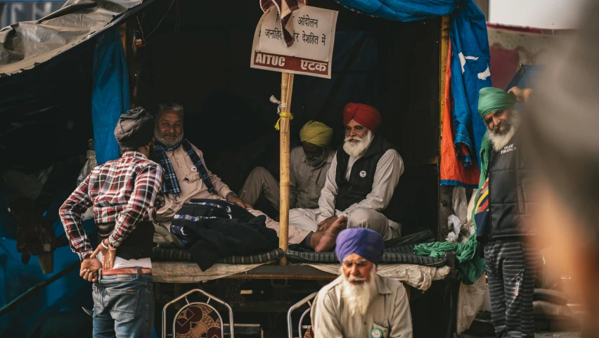 a couple of men are sitting in the back of a truck