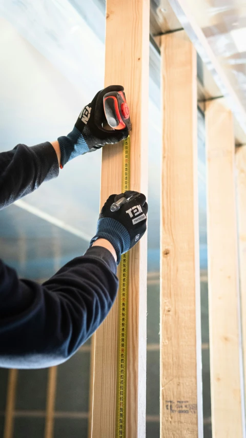 a person with two large wooden pieces with measuring tape