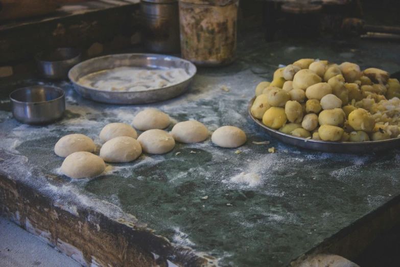 raw balls of bread being made and put in tins