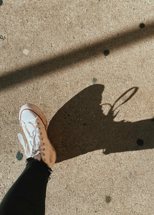 shadow of person's legs with tennis racket
