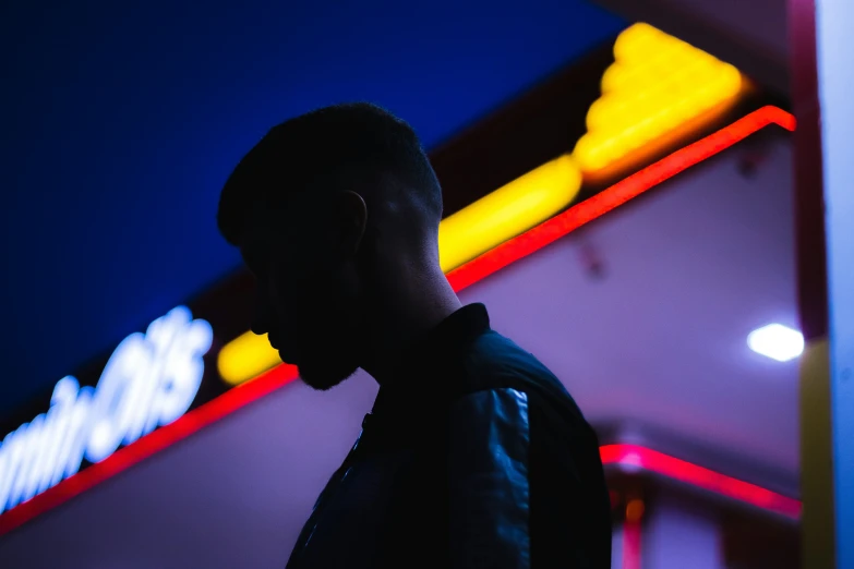 a man that is standing next to a neon sign