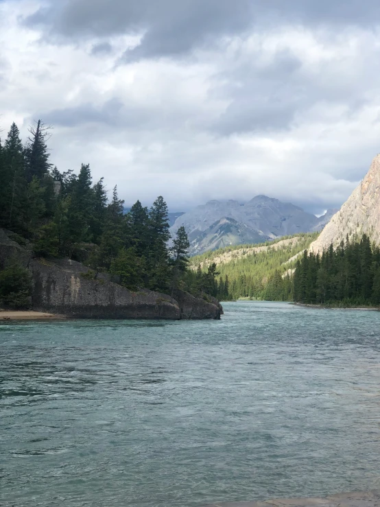 a body of water sitting between some trees and mountains