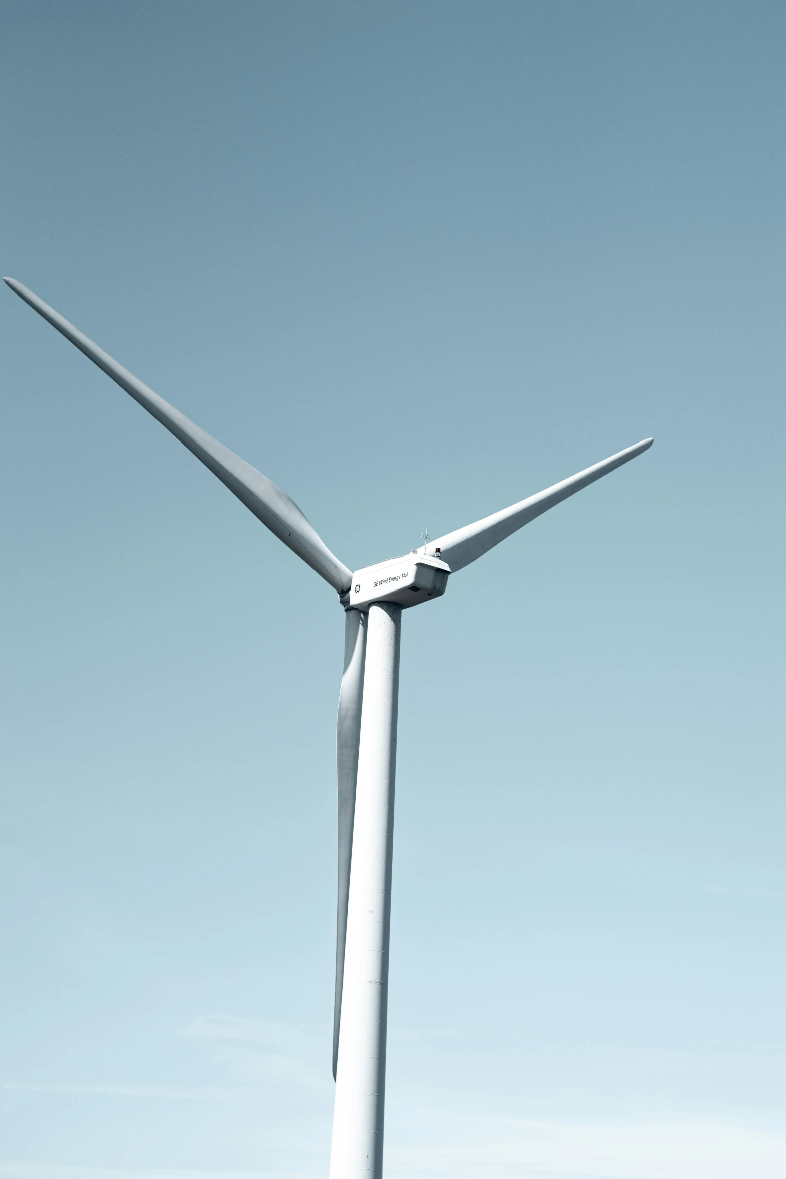 the view from below of a large white wind turbine