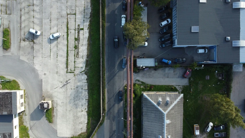 aerial s of a parking lot, a paved roadway and the surrounding house