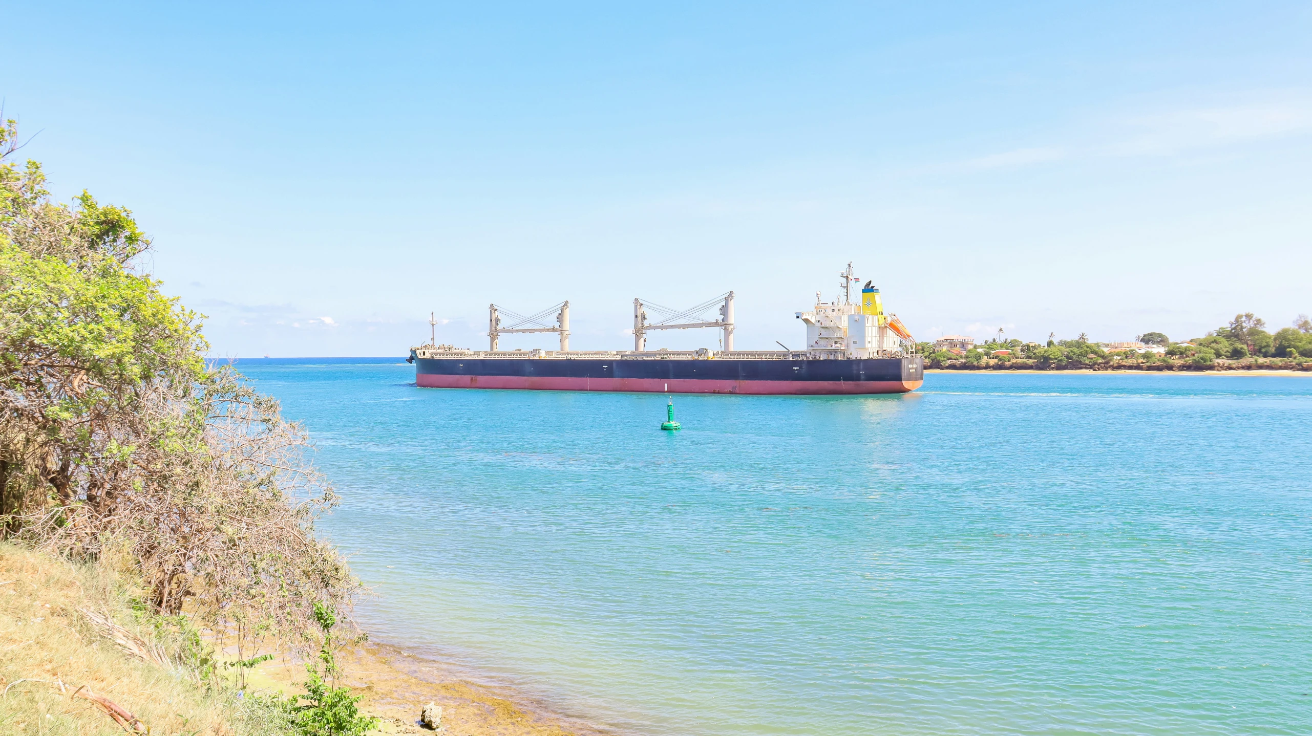 a boat out on the water under a blue sky