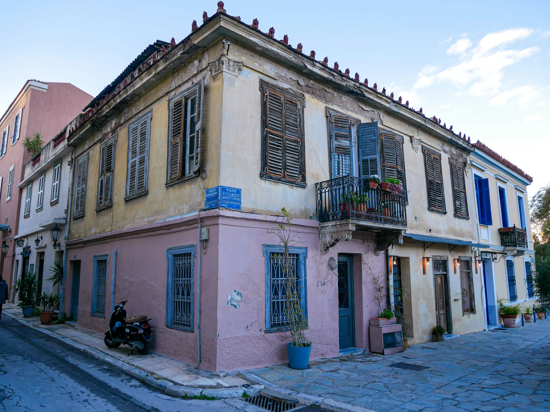 an old pink building with blue shutters