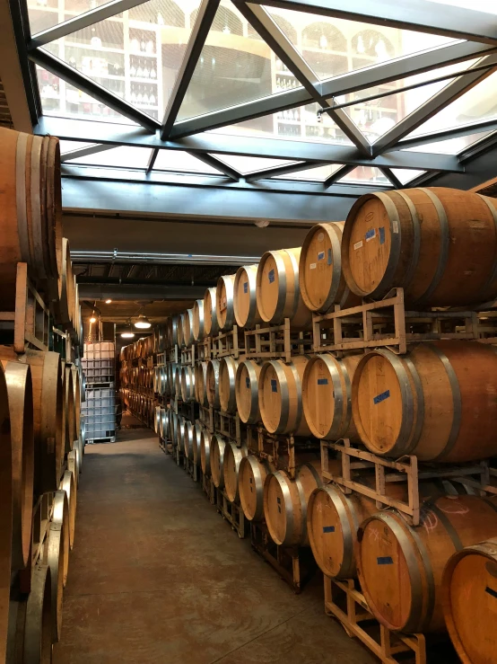 wine barrels stacked in a room with a roof