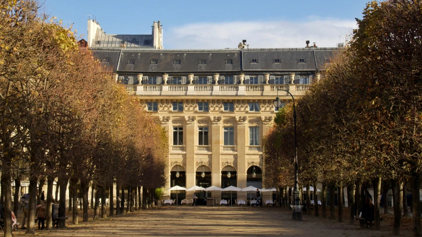 a large building with an outside courtyard and trees lining the path