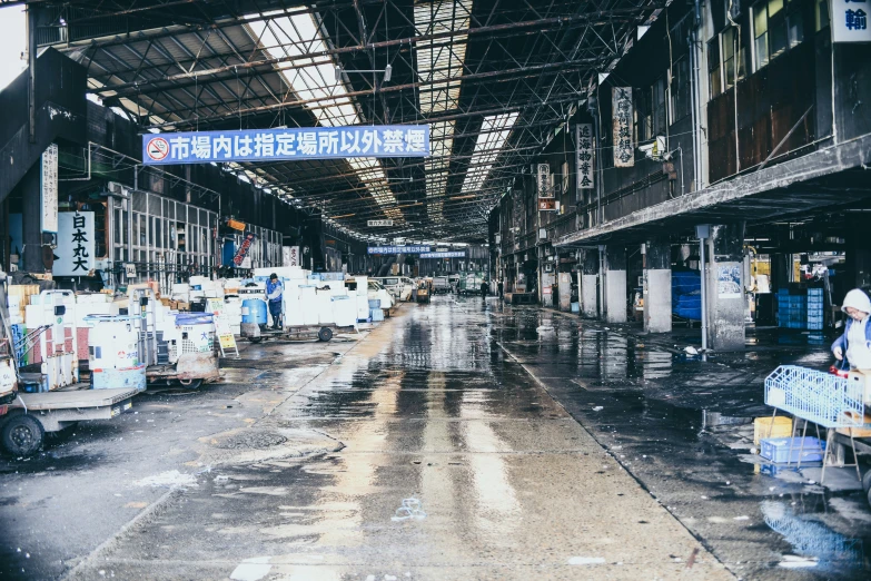 an asian market with lots of stalls and large banners hanging from the ceiling