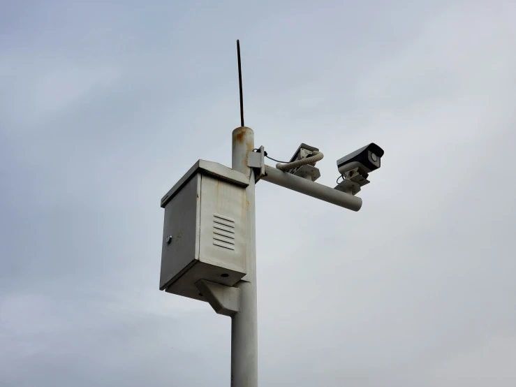 two cameras on top of a traffic light