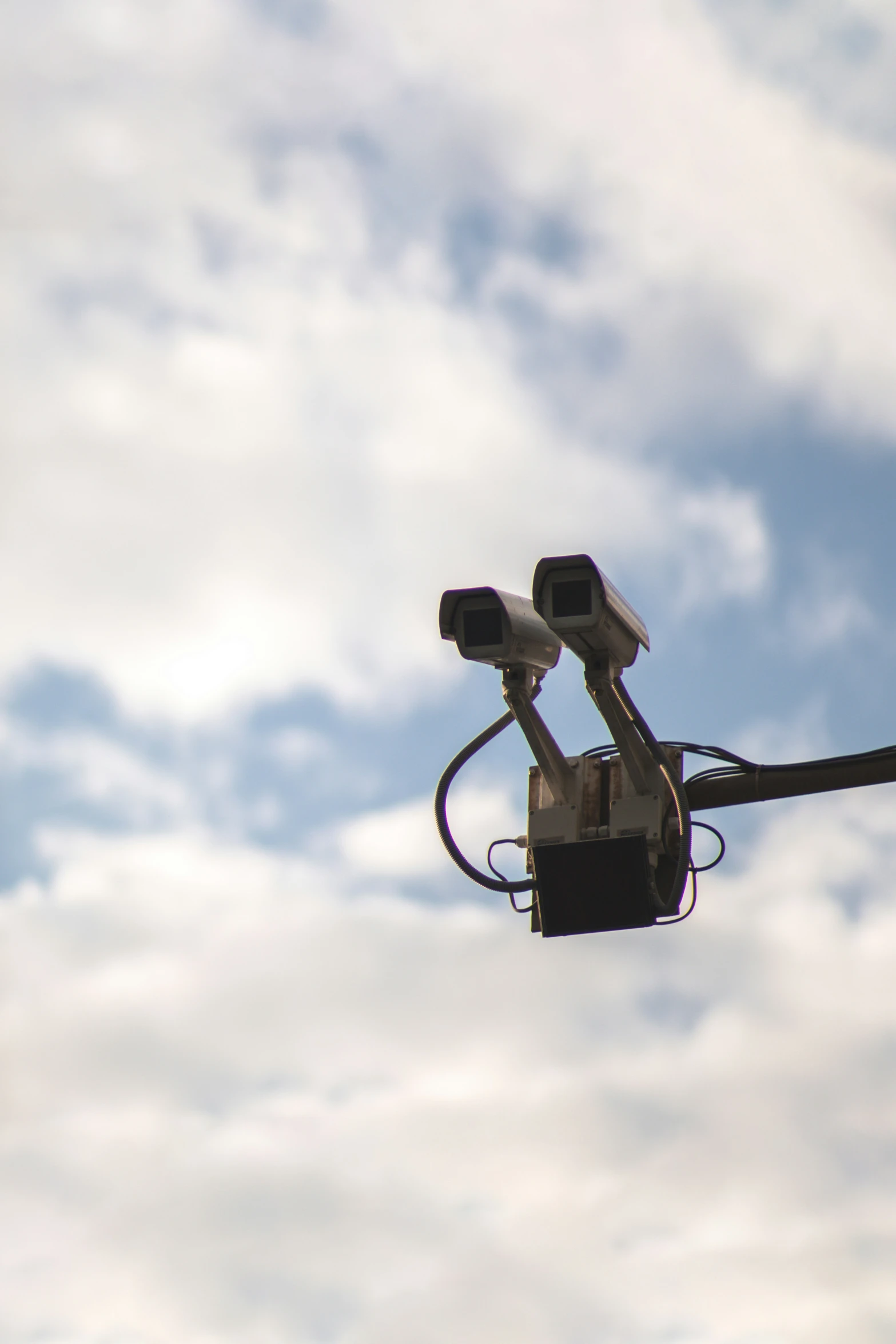 two cameras attached to a rail set against the sky