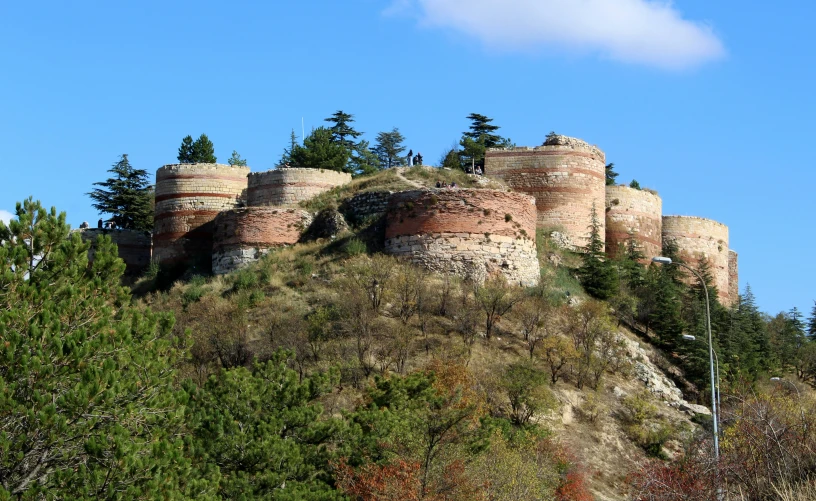 an ancient building is on a very hill