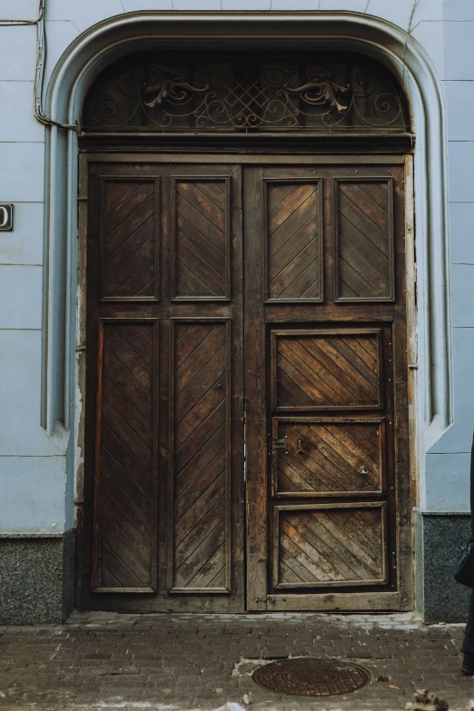 the front door of an old building with a person walking next to it