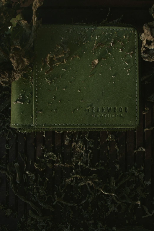 a green book on a stone surface with scratches