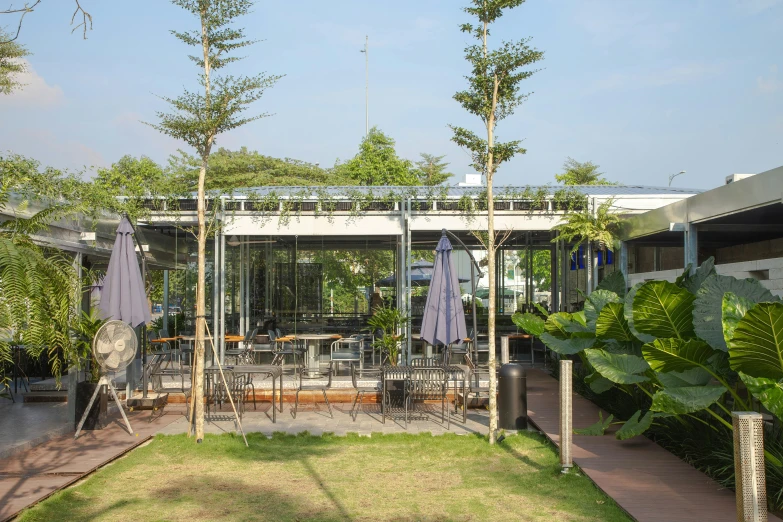 an outside patio covered in plants and umbrellas