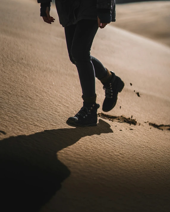 someone standing in the sand near their footprints