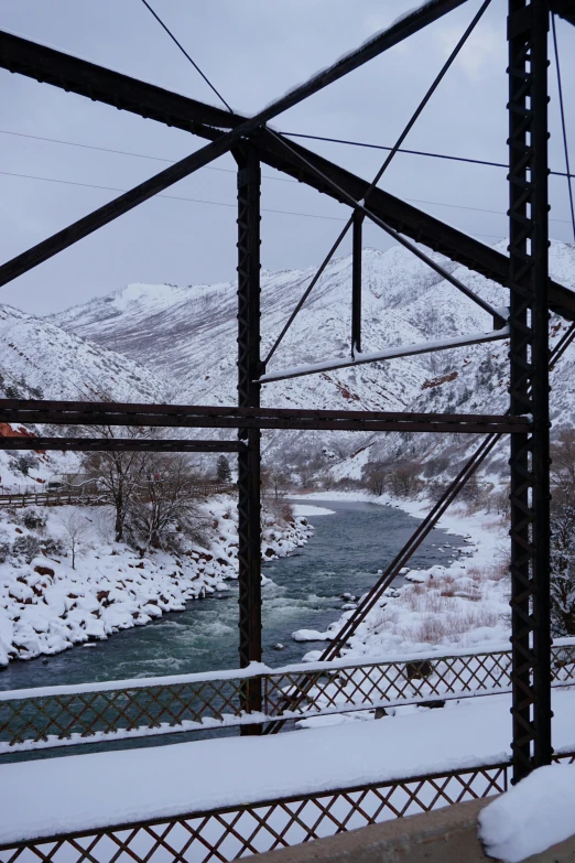 the train tracks are covered in snow as it is coming up to a stream