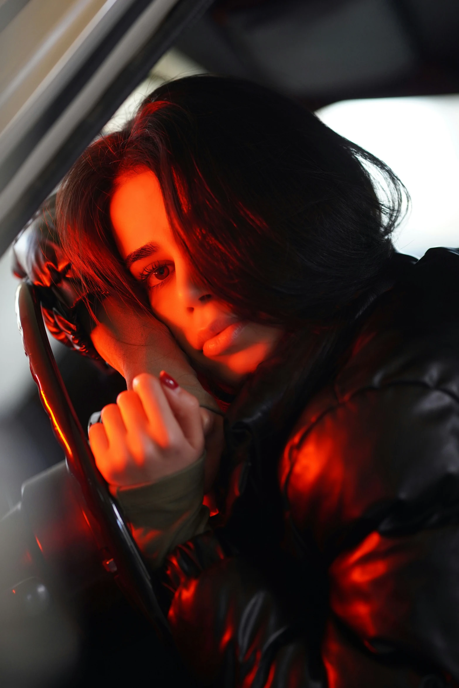 a woman is sitting in a car with her hand on the steering wheel