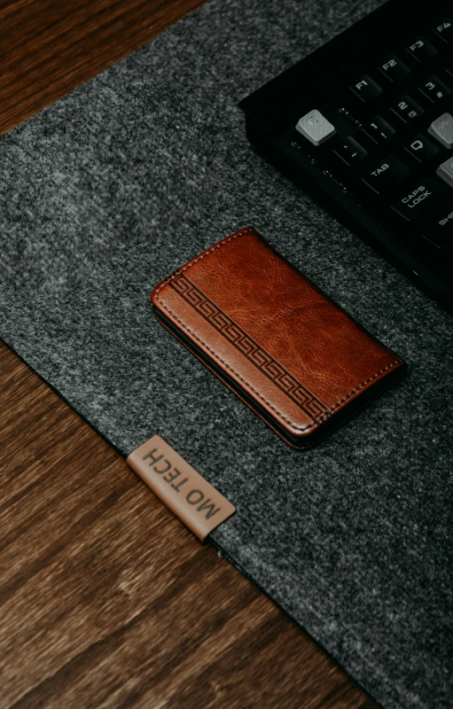 a laptop on the ground with a brown leather sleeve