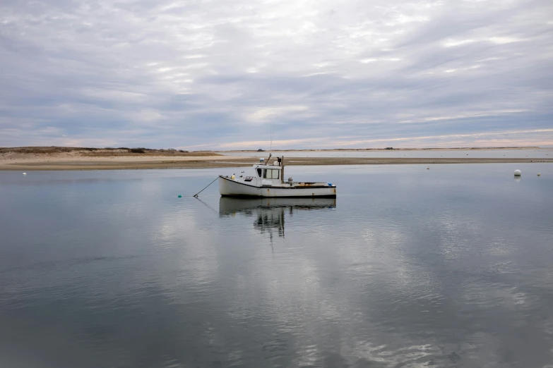 a small white boat sitting in a body of water