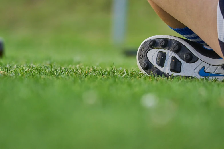 a person bending down toward the ground with shoes on