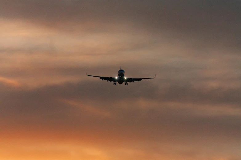 an airplane flying into the sunset on its flight line