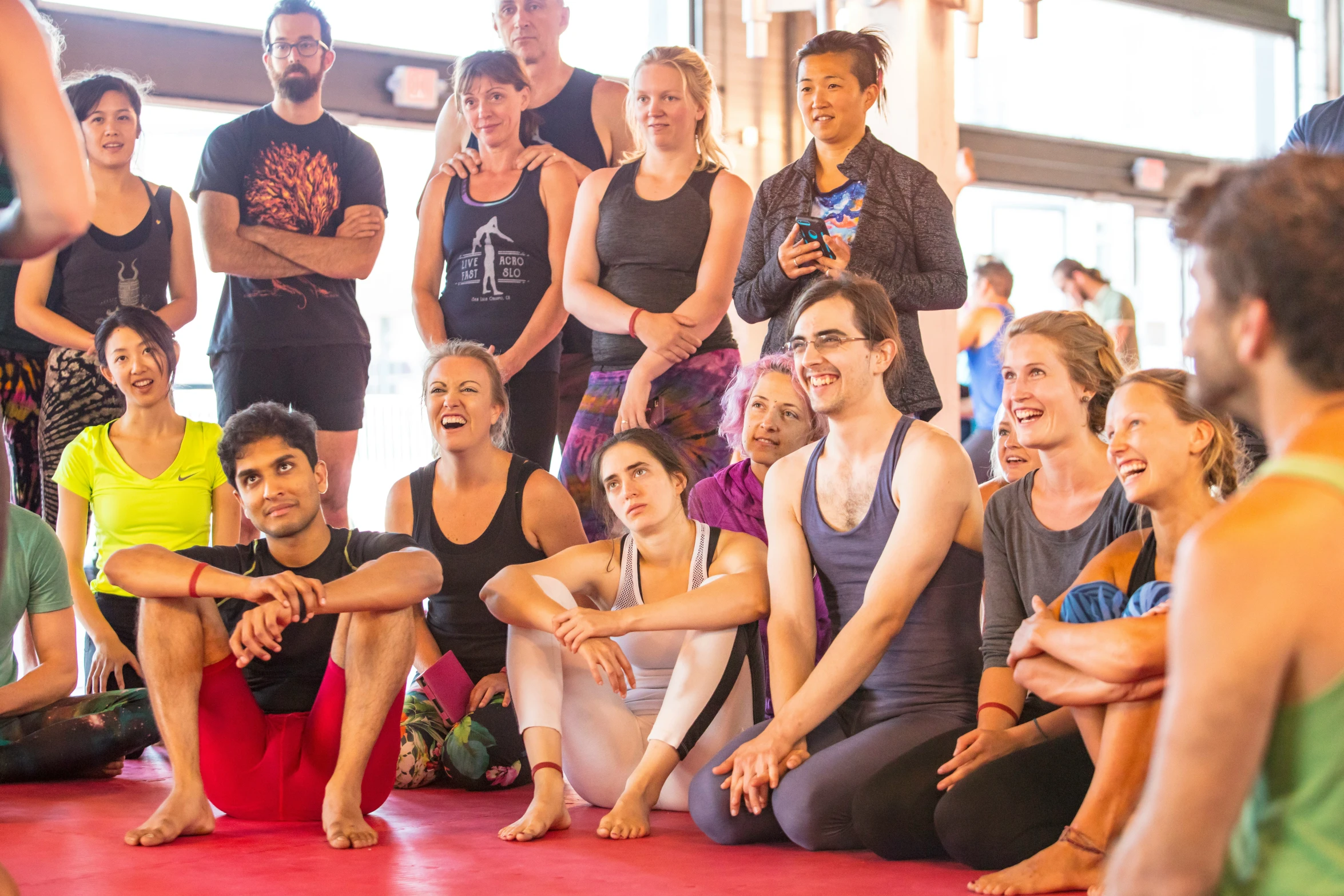 many people in a group sitting and standing together