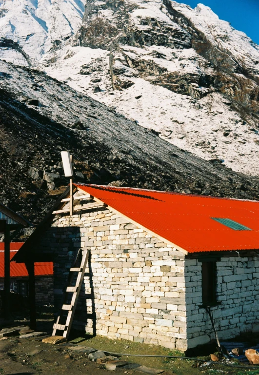 a building with an orange roof sitting next to mountains