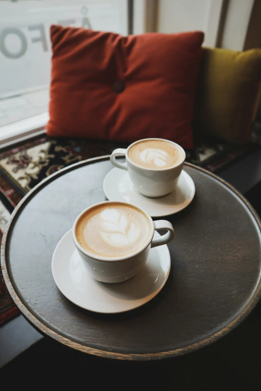 two coffee cups sitting on top of a table