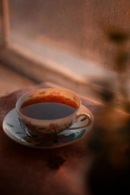 a tea cup and saucer sitting on top of a table