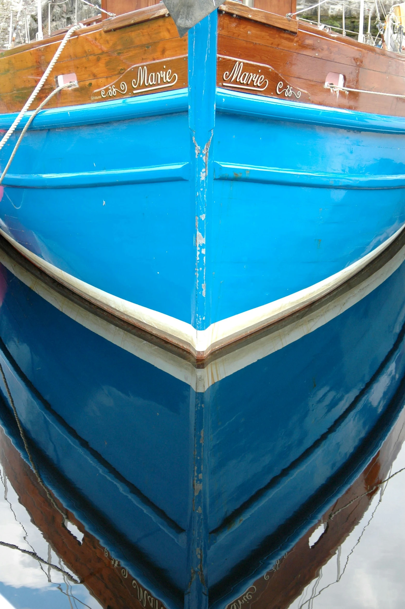 blue boat on water at dock in marina