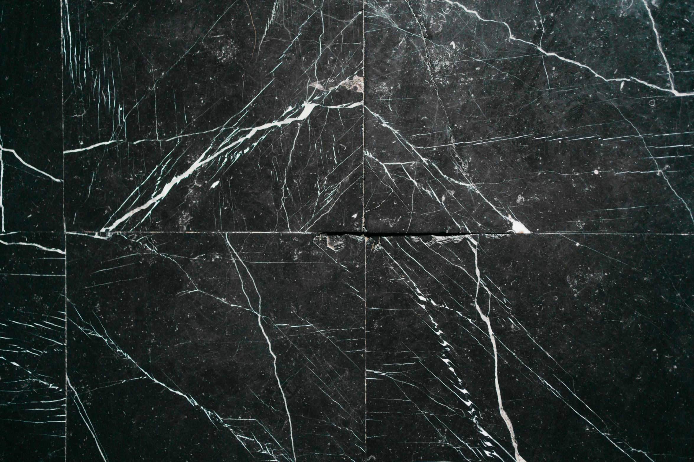 black marble with white scratches against a dark background