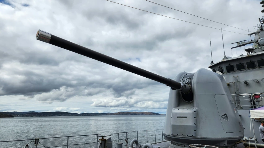 a large battleship sits on the ocean with people standing outside