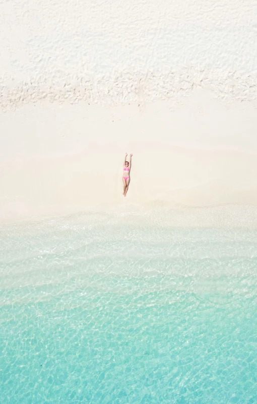 two people walking along a beach in the sand